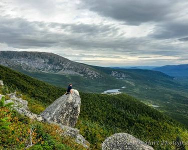 "Keep Ridge I" - A hiker perches on a boulder along the Helon Taylor Trail, absorbing the view to the north towards the Basin Ponds and Hamlin ridge.