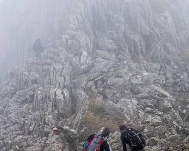 "Crossing the Knife Edge VI" - A hiking party approaches and carefully traverses one of the narrow "bridges" of Mt. Katahdin's Knife Edge in winds in excess of 40 mph.