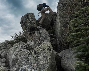 "Ascending Keep Ridge I" - A hiker ascends the boulders of the Helon Taylor Trail.