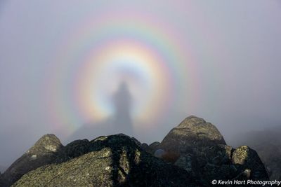 The shadow of the photographer is fully enclosed in a circular rainbow.